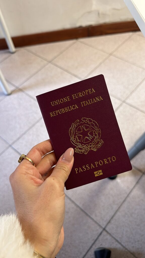 Mão segurando passaporte italiano