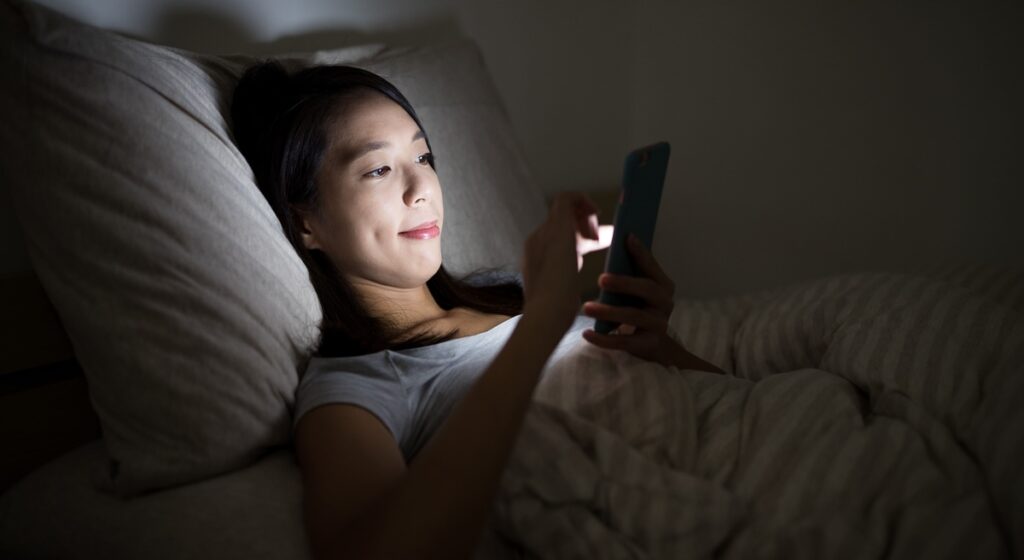 Mulher usando o celular à noite