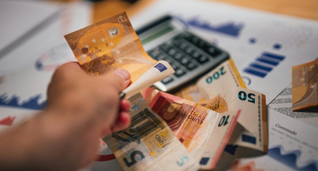 Mão segurando várias cédulas de euro