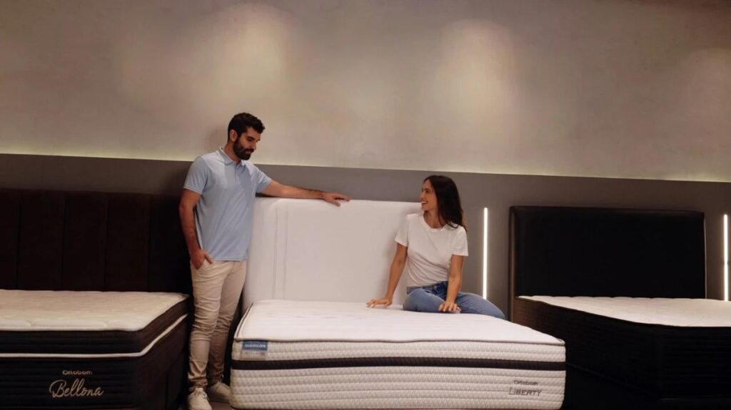 Casal na cama escolhendo colchão