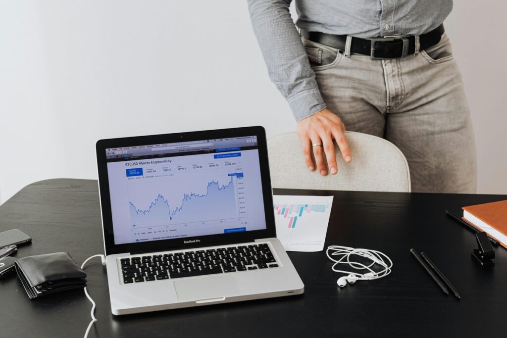 Mesa com laptop e gráfico de Bitcoin