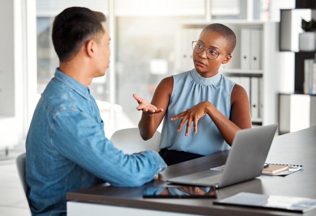 Homem e mulher conversam no escritório