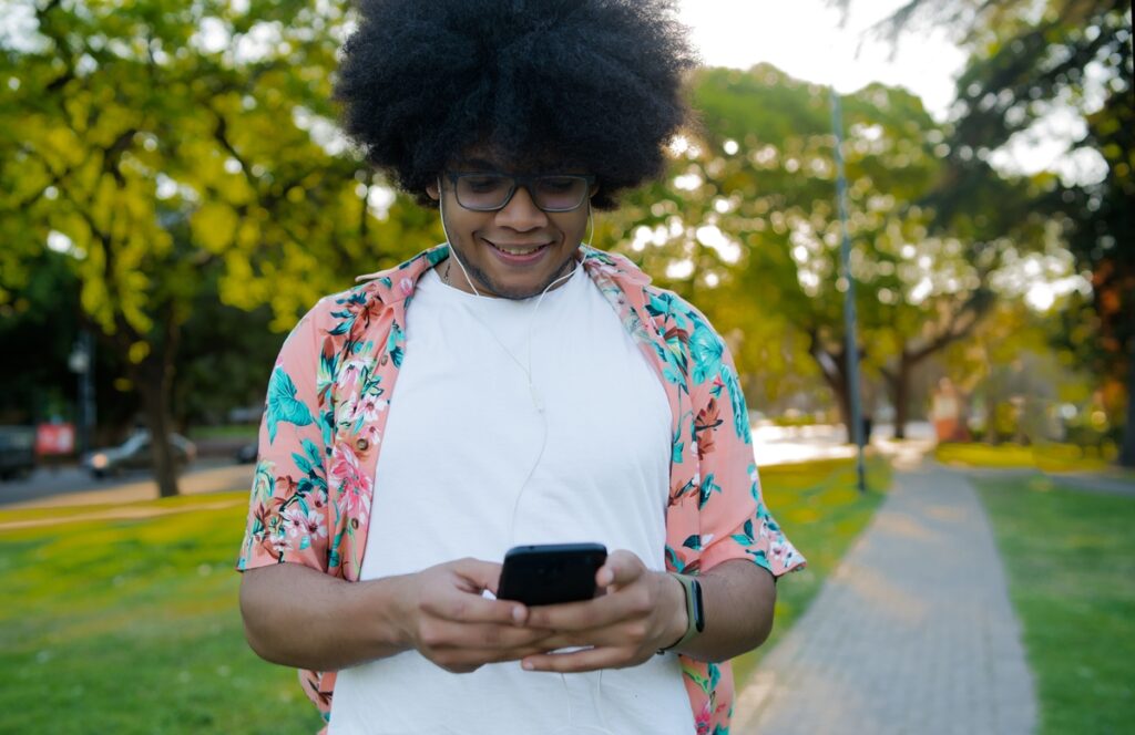Jovem sorridente mexendo no celular