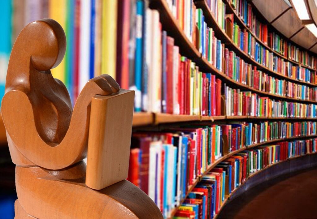 Escultura lendo com fundo de biblioteca
