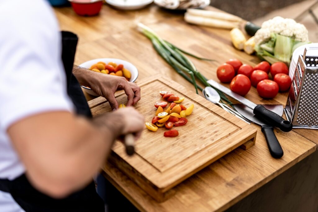 Pessoa em cozinha, cortando legumes