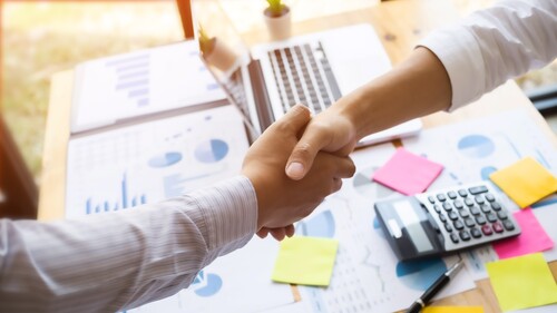 Business executives shaking hands after meeting at office, colleagues management
