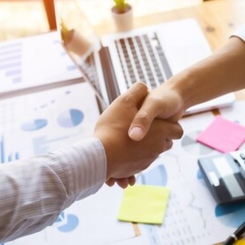 Business executives shaking hands after meeting at office, colleagues management